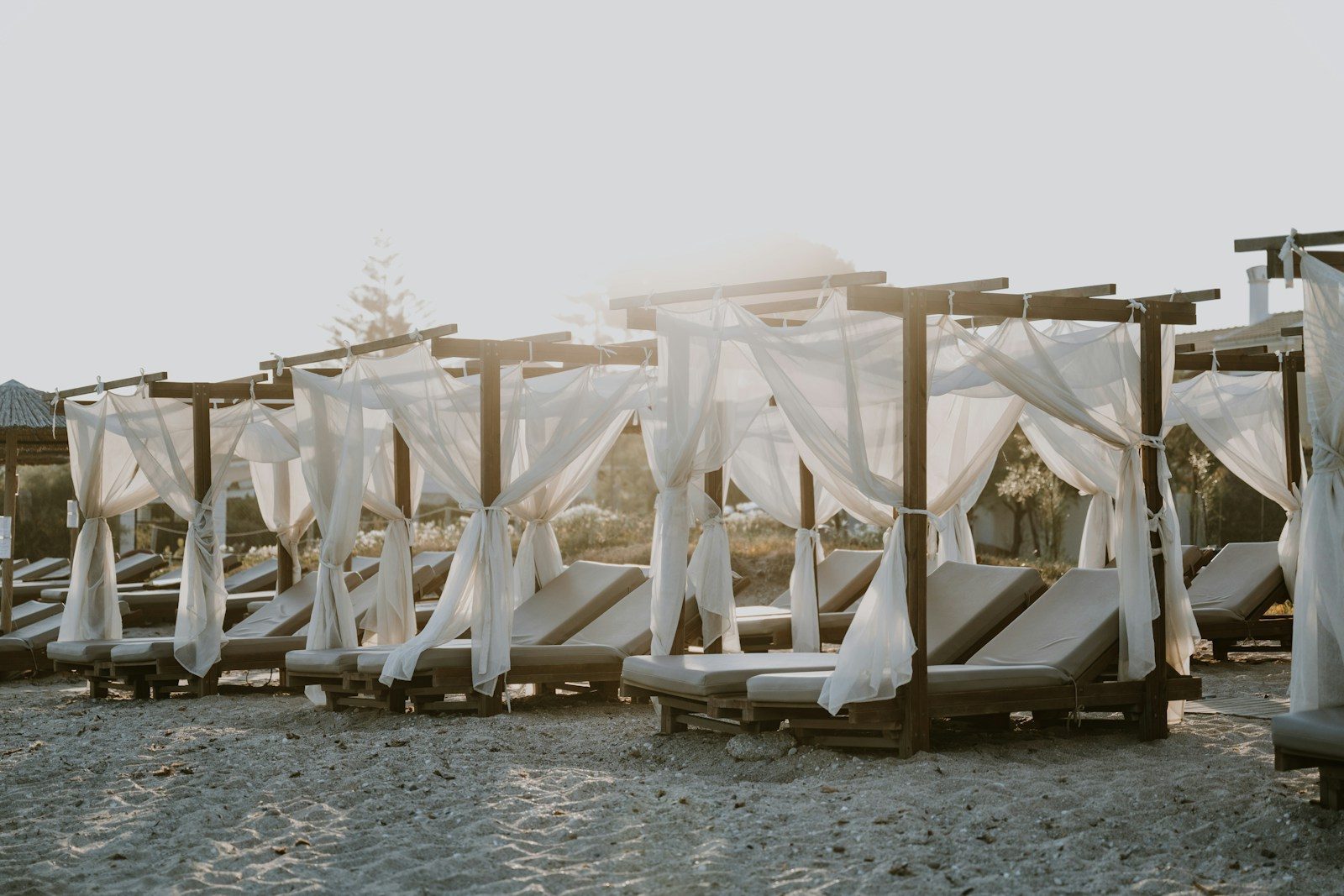 Hamacas con velos blancos a pie de arena en Aira Beach Club