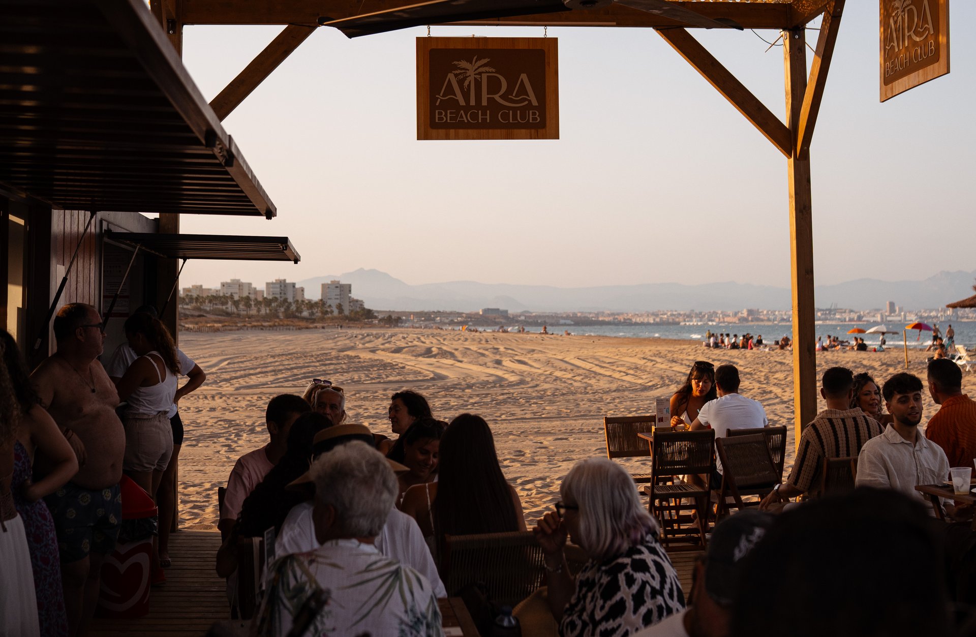 La terraza de Aira Beach Club llena al atardecer, a pie de arena en la Playa de El Altet, Elche (Alicante)